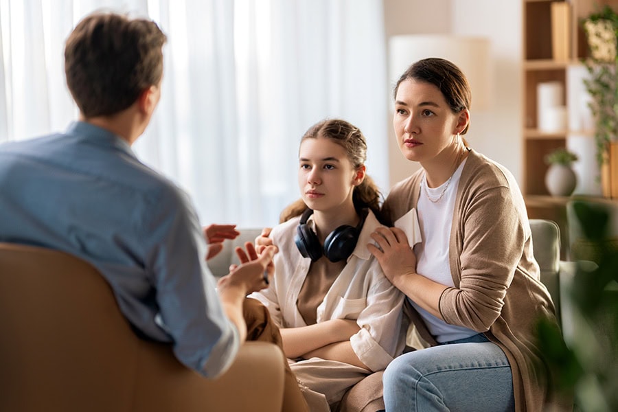 Parent and teenager talking with a mental health professional about when to seek more help during the social media ban for under 16s