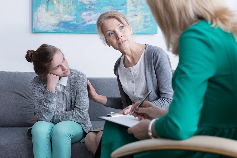 Behaviour support practitioner meeting with a parent and child to discuss school-related anxiety