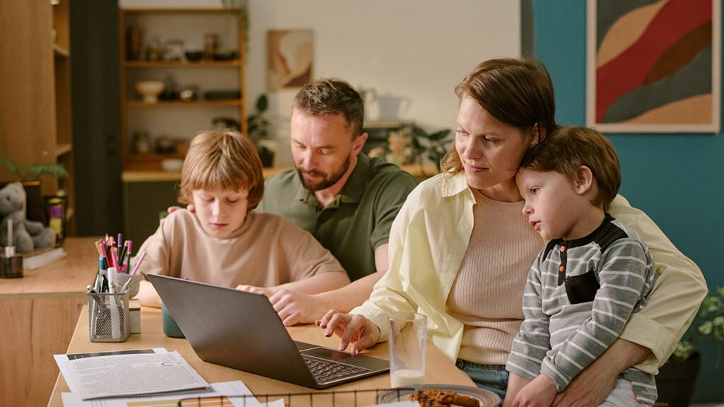 Family preparing evidence for an NDIS plan reassessment at a kitchen table