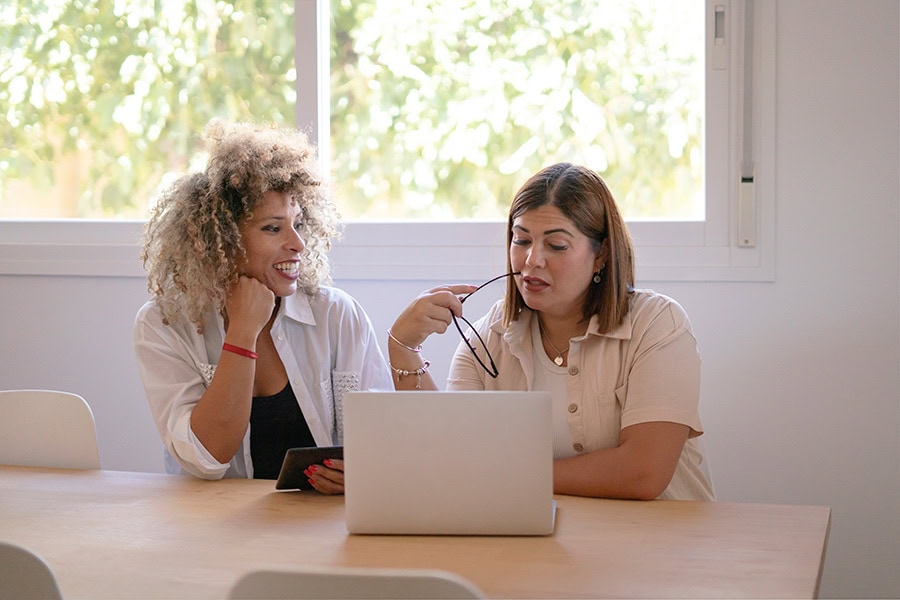 Behaviour Practitioner and support worker reviewing NDIS social and community participation records together