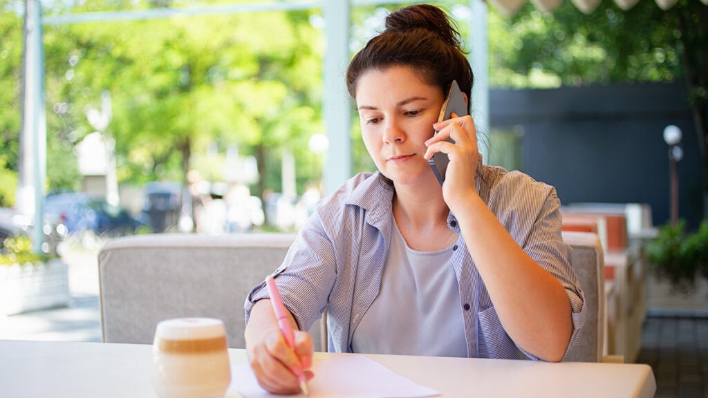 Support worker recording notes after a community outing to support NDIS social and community participation