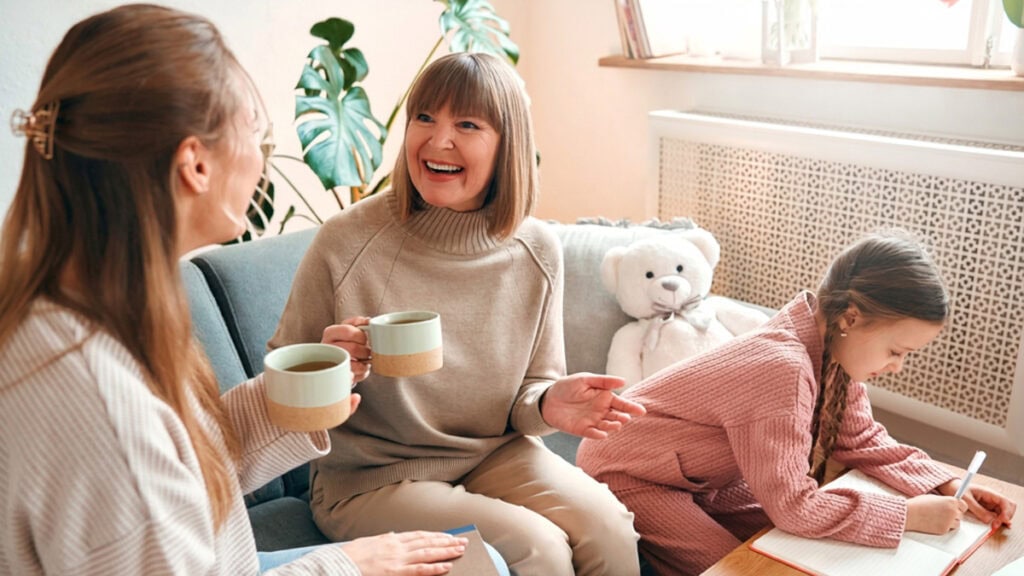 Family talking with a practitioner about NDIS positive behaviour support at a kitchen table